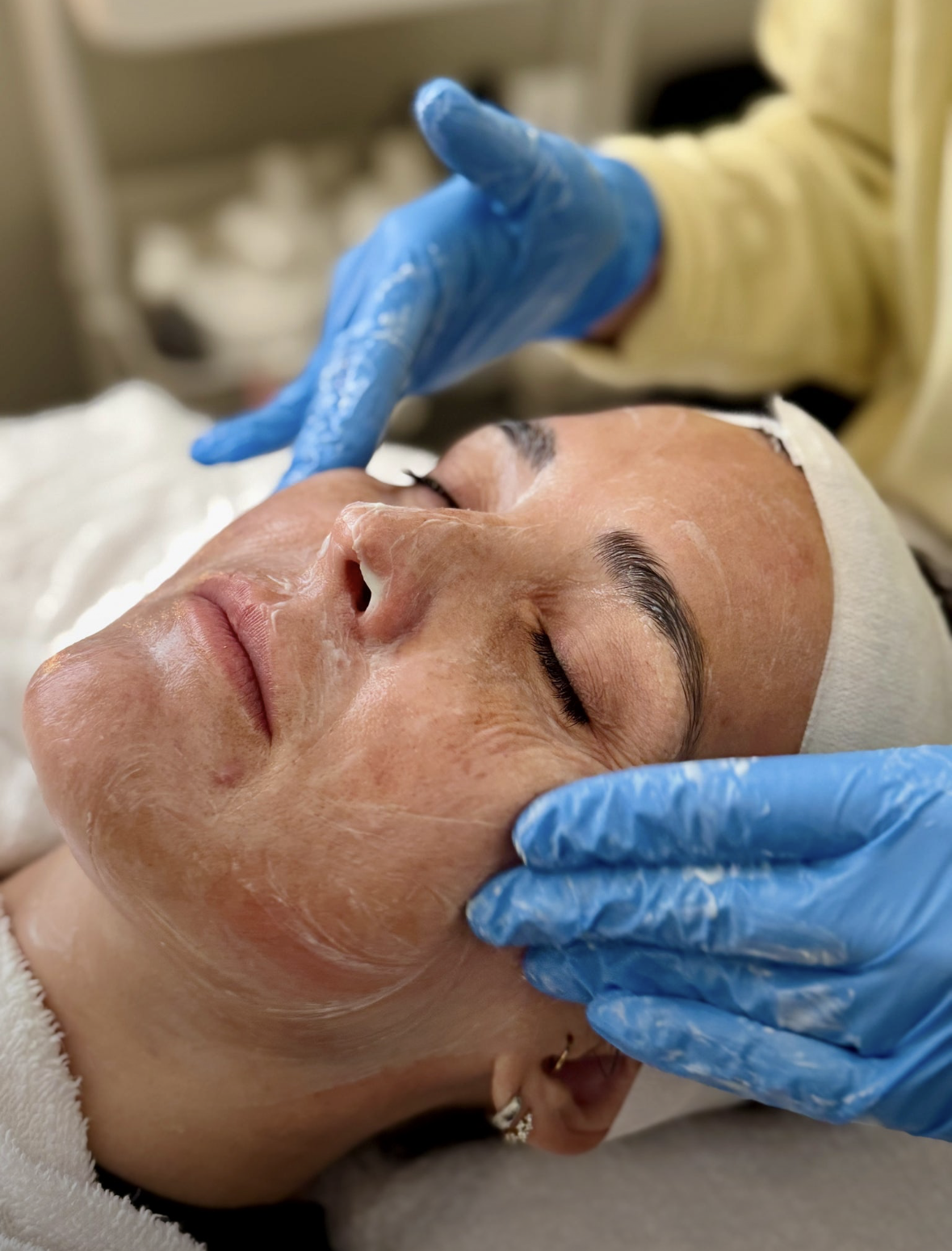 Shine esthetician applying a treatment mask during a facial at the Starkville studio